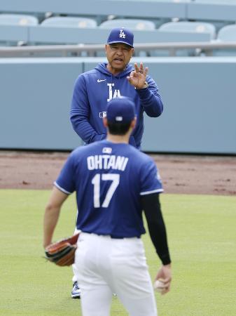 　大谷（手前）と話をするドジャースのロバーツ監督＝４月、ロサンゼルス
