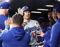 　ロッキーズ戦の６回、27号２ランを放ちベンチで迎えられるドジャース・大谷。日米通算３００号に到達した（共同）