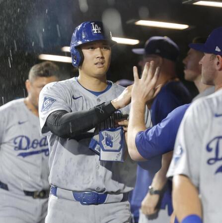 　６回、マンシーの一塁適時内野安打で生還し、タッチを交わす大谷（共同）