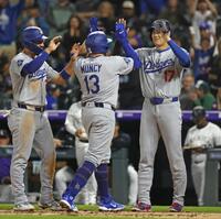 　７回、満塁本塁打を放ったマンシー（13）とタッチを交わす大谷（右）＝共同