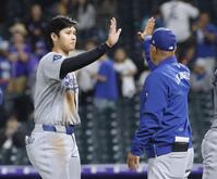 　ロッキーズに勝利し、ロバーツ監督（右）とタッチを交わす大谷（共同）