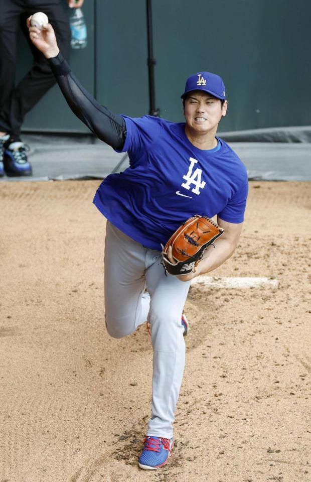 　ブルペンで投球する大谷（共同）