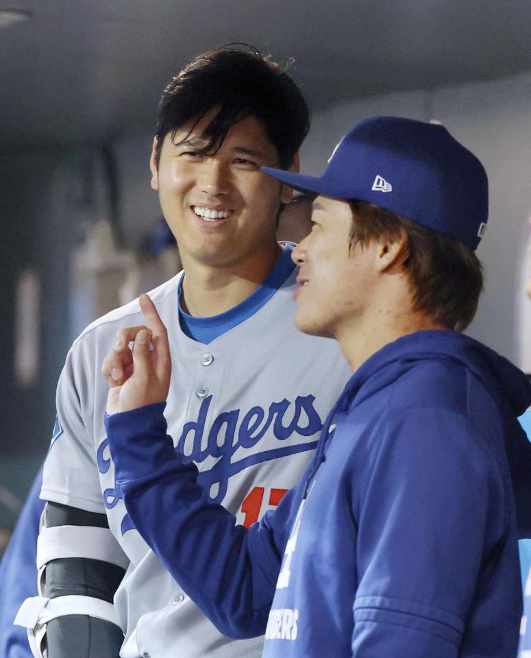 　８回、ベンチで山本（手前）と話す大谷（共同）