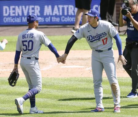 　ロッキーズに勝利し、ベッツ（左）とタッチする大谷（共同）