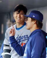 　ロッキーズ戦の８回、ベンチで山本（手前）と話すドジャース・大谷（共同）