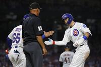 　ガーディアンズ戦の４回、２点打を放ち一塁コーチ（65）とタッチを交わすカブス・鈴木（共同）