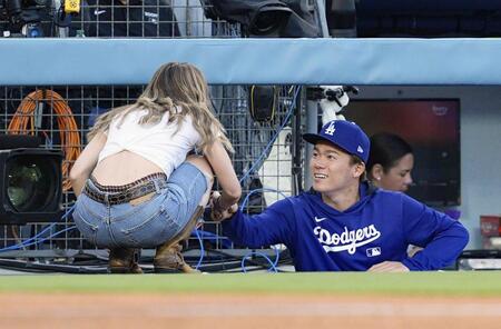 　始球式を務めたエミリー・ラッドさん（左）と話すドジャース・山本（共同）