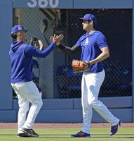 　キャッチボールを終え、タッチを交わす大谷（右）＝共同