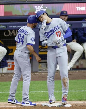 　ブルワーズ戦の８回、右前打で出塁し、一塁コーチとヘルメットを合わせるドジャース・大谷＝ミルウォーキー（共同）