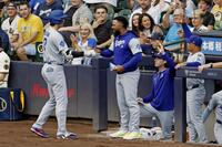 　ブルワーズ戦の１回、３１号ソロを放ち迎えられるドジャース・大谷。右端はロバーツ監督（共同）