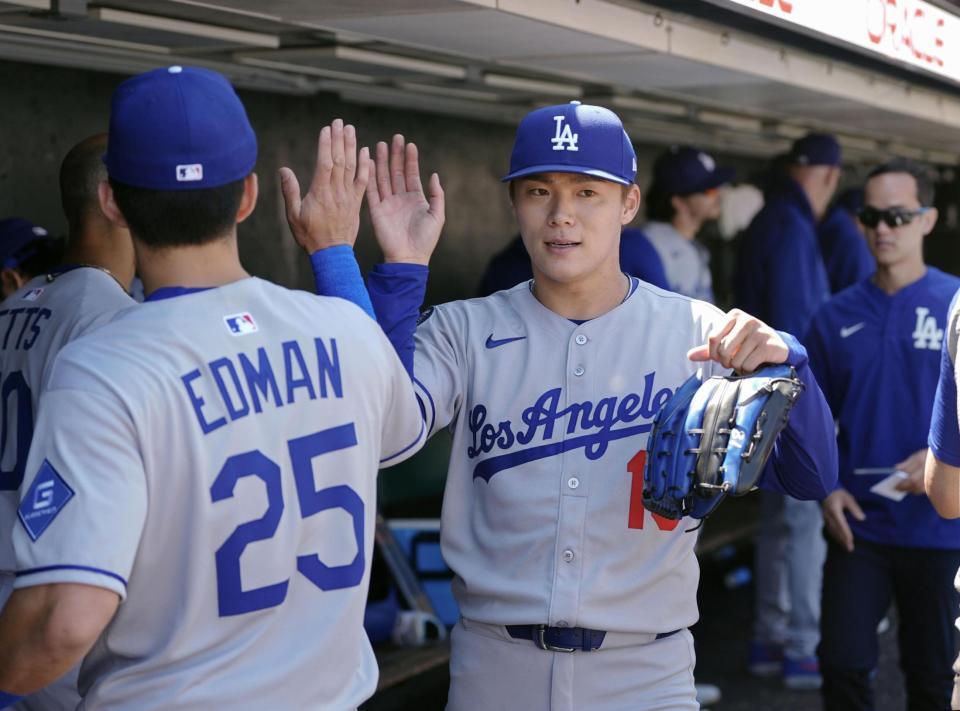 　ジャイアンツ戦の７回を投げ終え、ベンチでタッチを交わすドジャース・山本（共同）