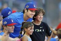 　子どもたちと写真に納まる大谷（中央左）と山本（左手前）＝共同