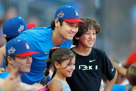 　子どもたちと写真に納まるドジャース・大谷（中央左）と山本（左手前）＝共同