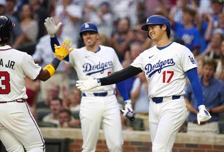 　１回、後続の２点打で二塁から先制のホームを踏み、続く一走（左）を迎えるドジャース・大谷（右）＝共同