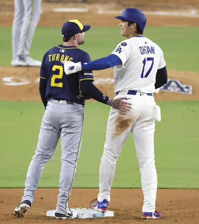 　６回、二盗のとき送球が大谷に当たったが、その後ブルワーズの二塁手（左）と言葉を交わした（共同）