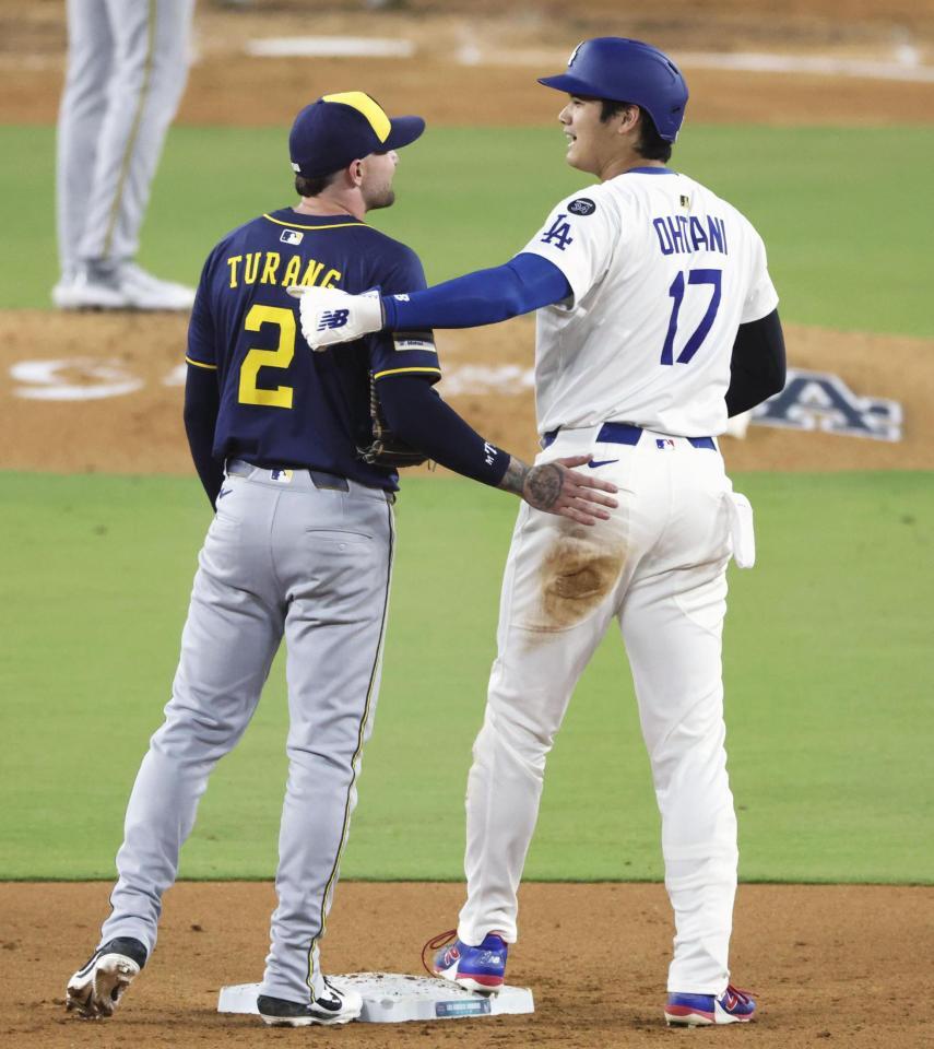 　６回、二盗のとき送球が大谷に当たったが、その後ブルワーズの二塁手（左）と言葉を交わした（共同）