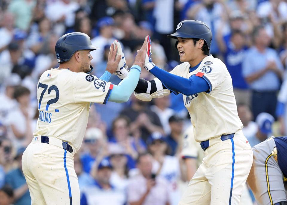 　ブルワーズ戦の３回、33ページ号２ランを放ちロハス（左）に迎えられる大谷（共同）