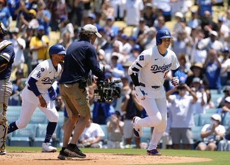 　ブルワーズ戦の３回、３４号２ランを放ち、共に生還したベッツ（左）とベンチに向かうドジャース・大谷（共同）