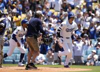 　ブルワーズ戦の３回、３４号２ランを放ち、共に生還したベッツ（左）とベンチに向かう大谷（共同）