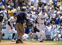 　ブルワーズ戦の３回、３４号２ランを放ち、共に生還したベッツ（左）とベンチに向かうドジャース・大谷（共同）