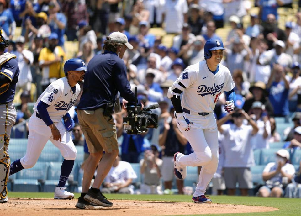 　ブルワーズ戦の３回、３４号２ランを放ち、共に生還したベッツ（左）とベンチに向かうドジャース・大谷（共同）