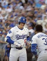 　ツインズ戦の１回、３５号２ランを放ち、祝福されるドジャース・大谷（共同）