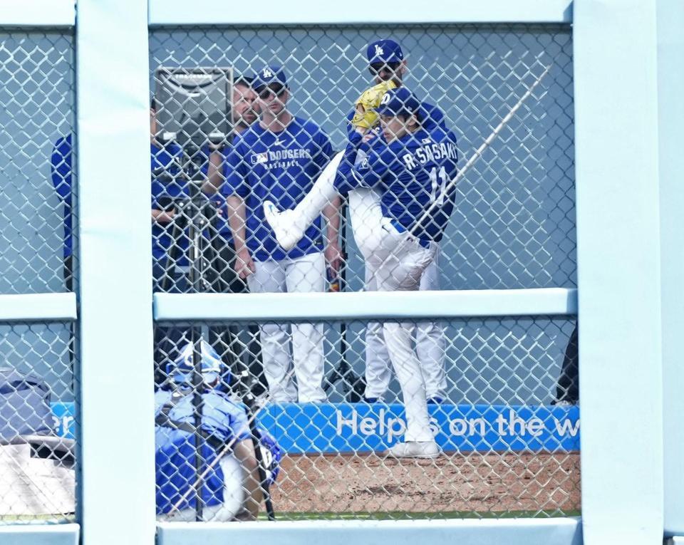 　ブルペンで投球練習する佐々木（共同）