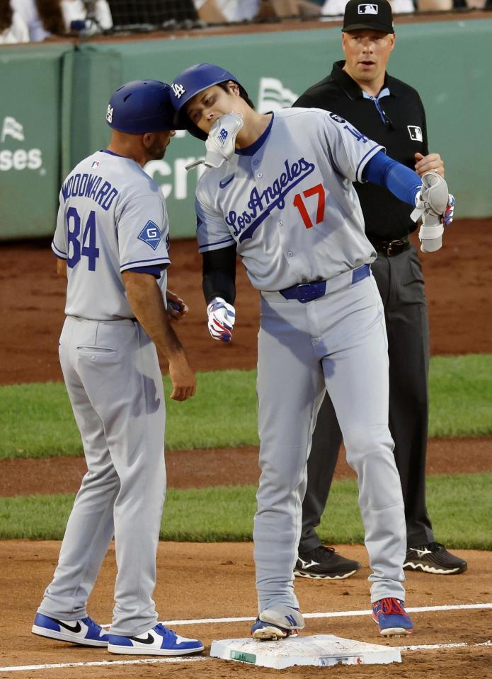 　３回、右前打を放ち、一塁コーチとヘルメットを合わせる大谷（共同）