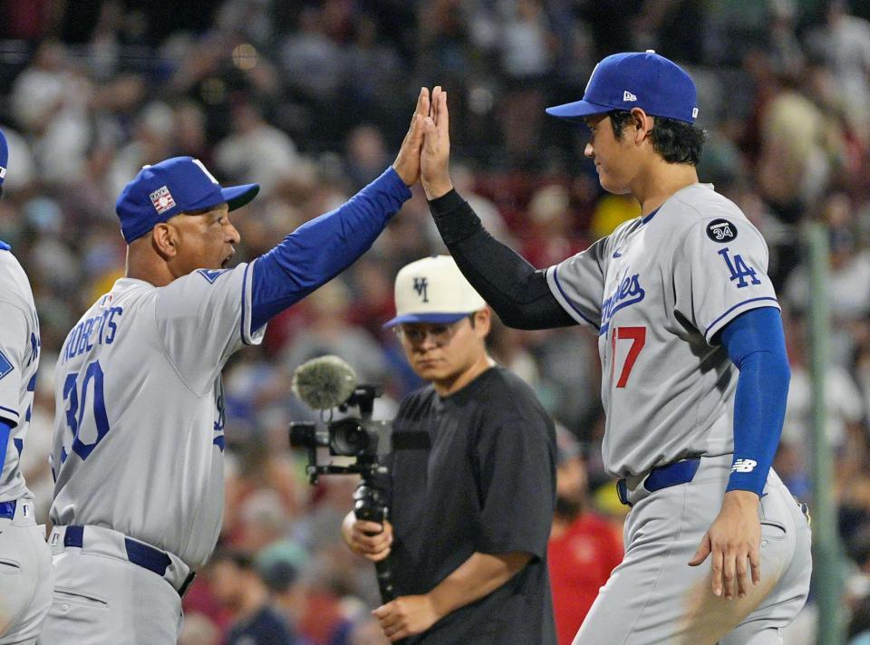 　レッドソックスに勝利し、ロバーツ監督（左）とタッチを交わす大谷（共同）