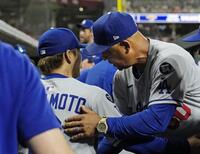 　先発し、７回１失点と好投した山本（左）をねぎらうロバーツ監督（共同）