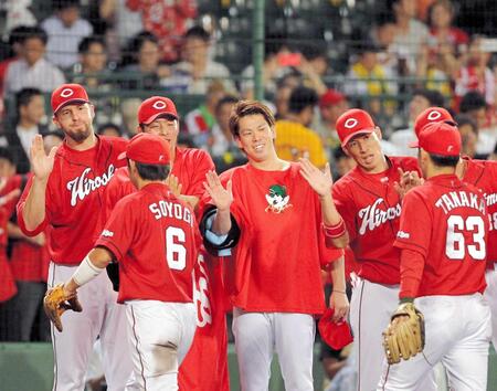 　ナインを笑顔で出迎える広島・前田健太（中央）。左はエルドレッド（２０１５年９月２日、甲子園）