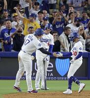 　ブルージェイズ戦の５回、逆転２ランを放ったベッツ（右）とタッチを交わす、先に生還した二走の大谷。中央は次打者フリーマン（共同）