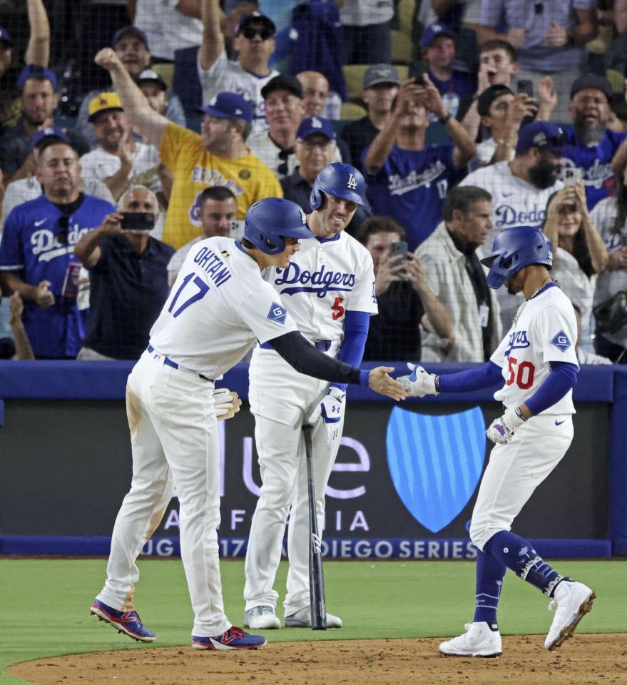 　ブルージェイズ戦の５回、逆転２ランを放ったベッツ（右）とタッチを交わす、先に生還した二走の大谷。中央は次打者フリーマン（共同）