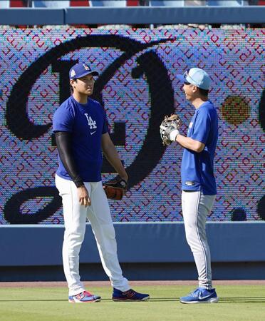 　試合前、ブルージェイズの運営補佐を務める加藤豪将さん（右）と話す大谷（共同）