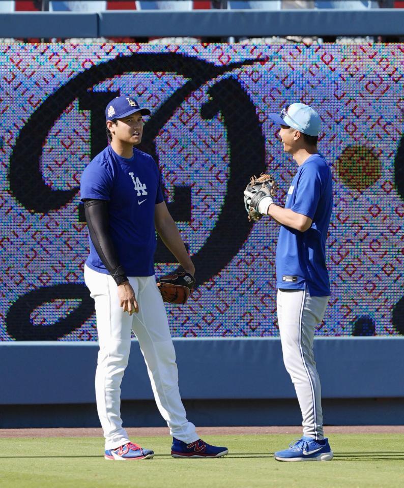 　試合前、ブルージェイズの運営補佐を務める加藤豪将さん（右）と話す大谷（共同）