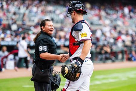 　米大リーグの公式戦で捕手と握手するパウォルさん＝１０日、アトランタ（ゲッティ＝共同）