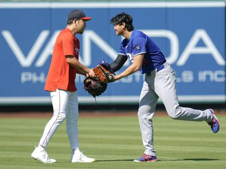 　握手する菊池（左）と大谷（共同）