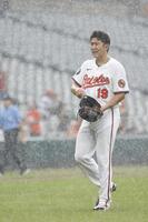 　６回途中、降雨により試合が中断し、ベンチに戻るオリオールズ・菅野（共同）