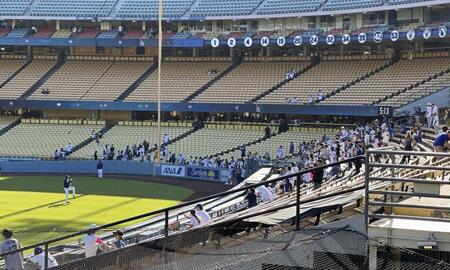 　キャッチボールする大谷（グラウンド内、手前）を見つめるファン（共同）