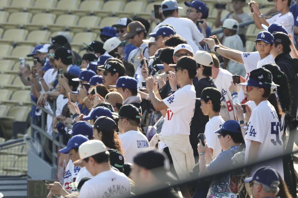 　キャッチボールする大谷を撮影するファン（共同）