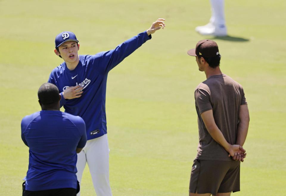 　ダルビッシュ（右）と話す佐々木（共同）
