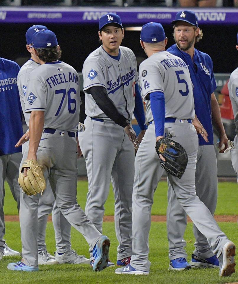 　勝利し、チームメートとタッチを交わす大谷（中央）＝共同