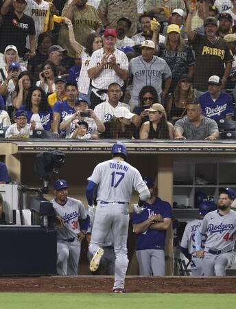 　パドレス戦の９回、右飛に倒れベンチに戻るドジャース・大谷。左はロバーツ監督（共同）