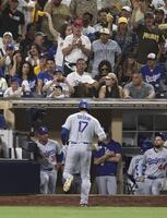 　パドレス戦の９回、右飛に倒れベンチに戻るドジャース・大谷。左はロバーツ監督（共同）