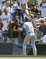 　パドレス戦の９回、45号ソロを放ち、ベンチ横にいたパドレスファンとタッチするドジャース・大谷（共同）