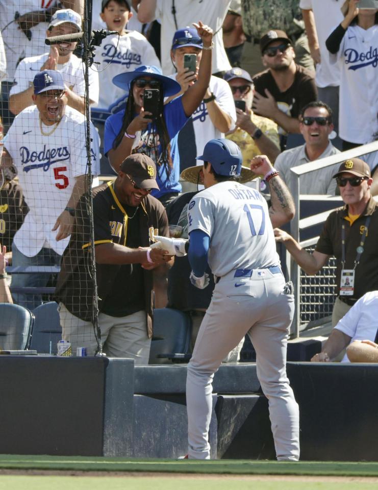 　パドレス戦の９回、45号ソロを放ち、ベンチ横にいたパドレスファンとタッチするドジャース・大谷（共同）