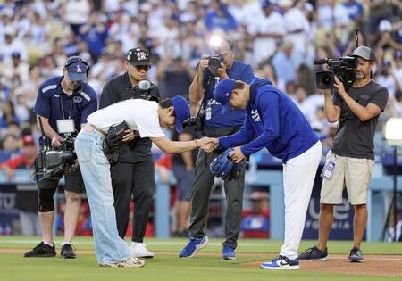 　捕手を務めた山本（右）と握手する、始球式を務めたＢＴＳのＶ（共同）