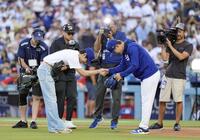 　捕手を務めた山本（右）と握手する、始球式を務めたＢＴＳのＶ（共同）