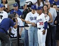 　始球式を行った後、ロバーツ監督（３０）と写真に納まるＢＴＳのＶ（共同）