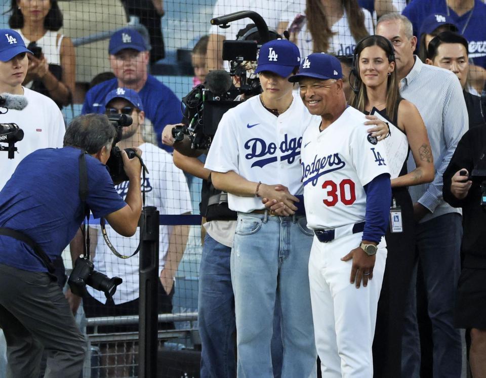 　始球式を行った後、ロバーツ監督（３０）と写真に納まるＢＴＳのＶ（共同）